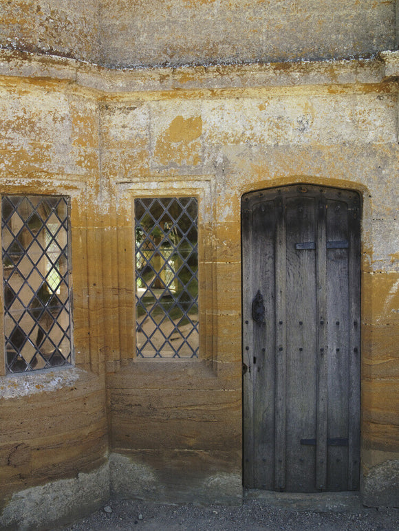 Wooden door and glittering glass windows at Montacute House, Somerset