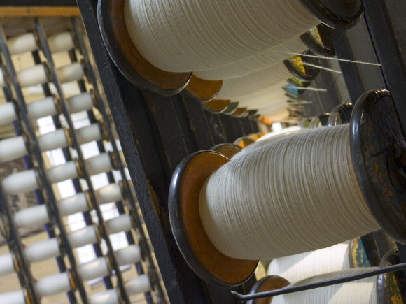 A view of a creel holding the bobbins used for warping which prepares the yarn for the loom at Quarry Bank Mill, Styal