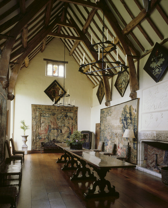 The Great Hall at Packwood House showing the timber ceiling, oak refectory table, 17th century Brussels tapestry depicting a terraced garden and bay window with heraldic glass