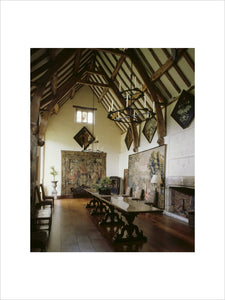 The Great Hall at Packwood House showing the timber ceiling, oak refectory table, 17th century Brussels tapestry depicting a terraced garden and bay window with heraldic glass