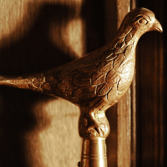 A brass bird tops a staff found in the Lobby at Snowshill Manor