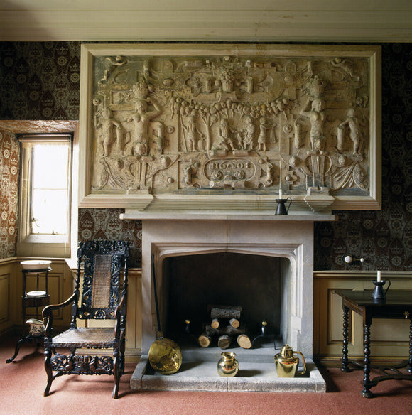 A close up of the fireplace and plasterwork over the mantelpiece in the King Charles Room