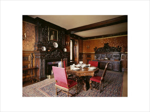 View of the Small Dining Room at Oxburgh Hall showing the table, chairs, fireplace and large wooden buffet