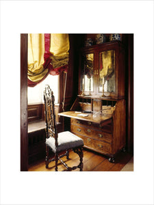 A close up of a chair and writing desk and cabinet in the Closet