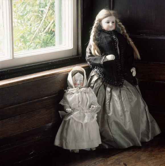 Shown on the window ledge in the bedroom at Hill Top are two French dolls which Beatrix said had belonged to her as a child although 'the shot silk dress is older'