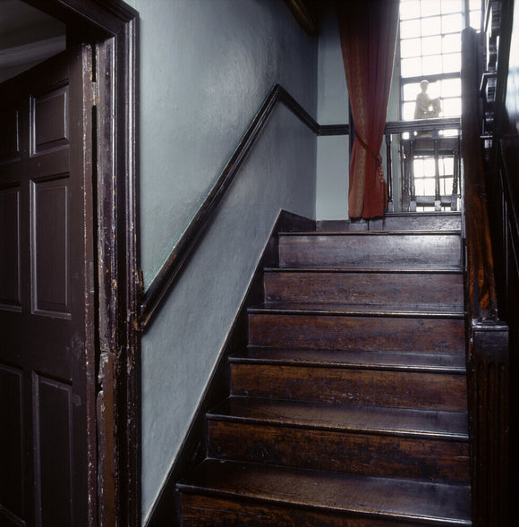 The staircase up to the half-landing, and oak mullion window at Hill Top