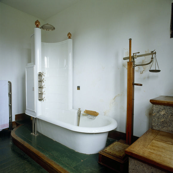 The Bathroom at Castle Drogo, showing the bath complete with shower compartment and old style weighing scales