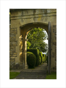 View through the stone entrance arch towards the topiary-flanked path at Westwood Manor