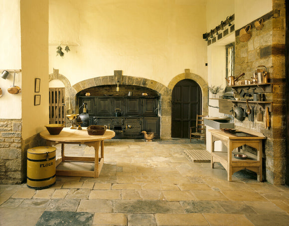 Canons Ashby - The Kitchen with Victorian cast iron range and cooking utensils and stone flagged floor