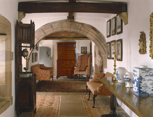A view of the Long Gallery, showing the rounded arch, wooden cross beam, C17th Flemish walnut refectory table with a collection of blue Delft jars opposite a C16th Dutch aumbry