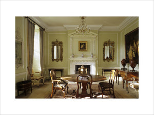 The Dining Room at Peckover House showing the C18th dining table and chairs and a two-tier chimneypiece set into the panelling from the same date