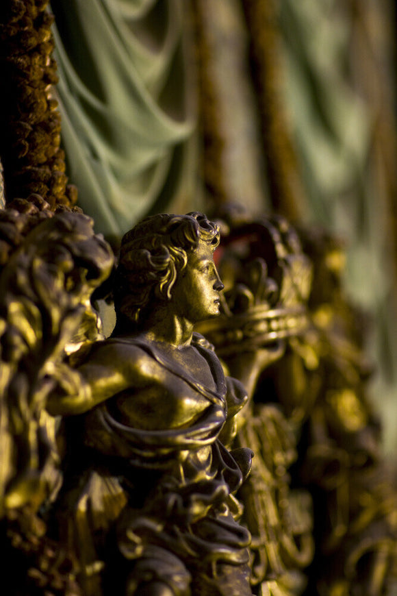 Detail of gilded figure on the headboard of the King James II bed prior to conservation and cleaning at Knole, Kent