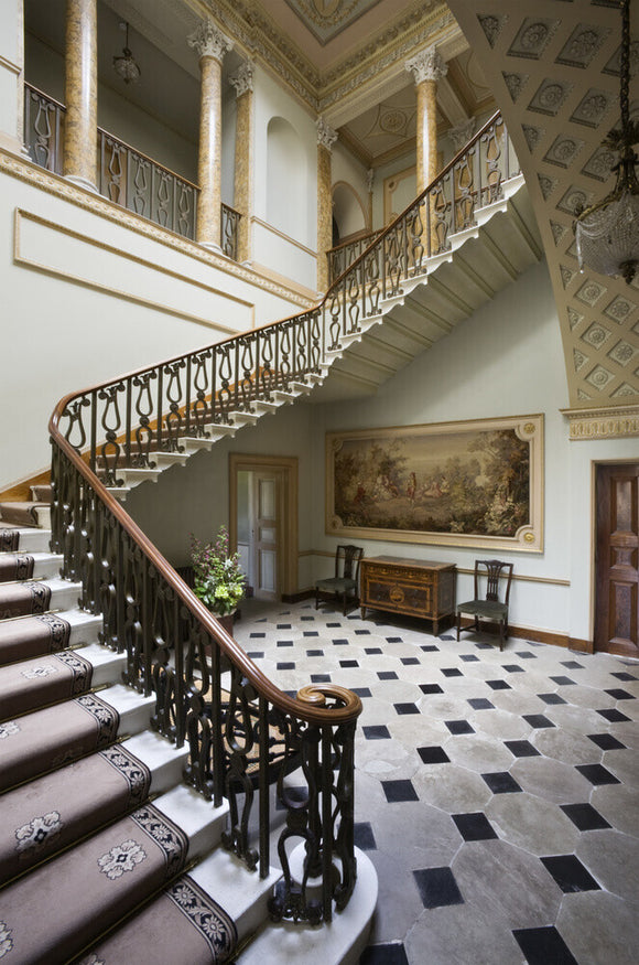 The sweeping staircase with bronzed balustrading in the Staircase Hall at Berrington Hall, Herefordshire