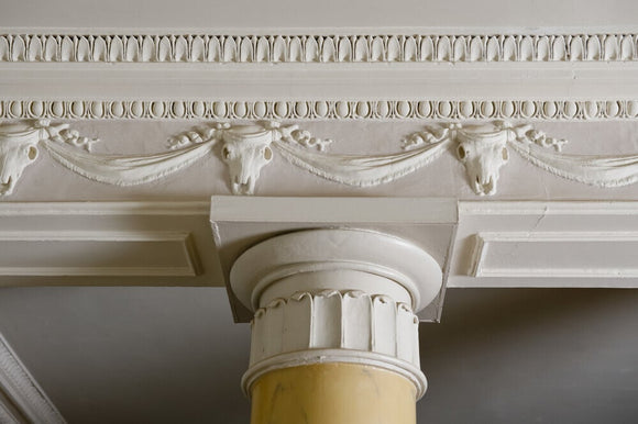 Close view of the frieze and part of the Doric columns in the Entrance Hall at Newark Park, Gloucestershire