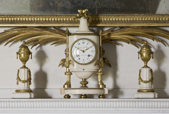 A Louis XV white marble clock by Julien Leroy flanked by a pair of casolettes