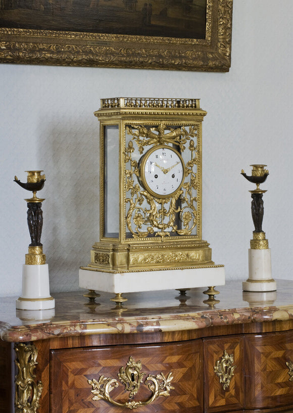 A French clock by Mignolet with a gilt bronze cage on a marble base